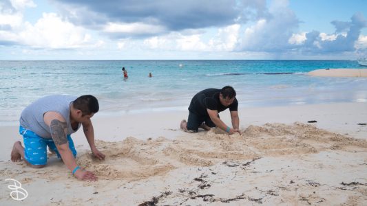 Wahyee and Mike creating a message in the sand. It was supposed to say, "Send Nudes", but the water kept washing away the bottom word. Creating a message in the sand...
